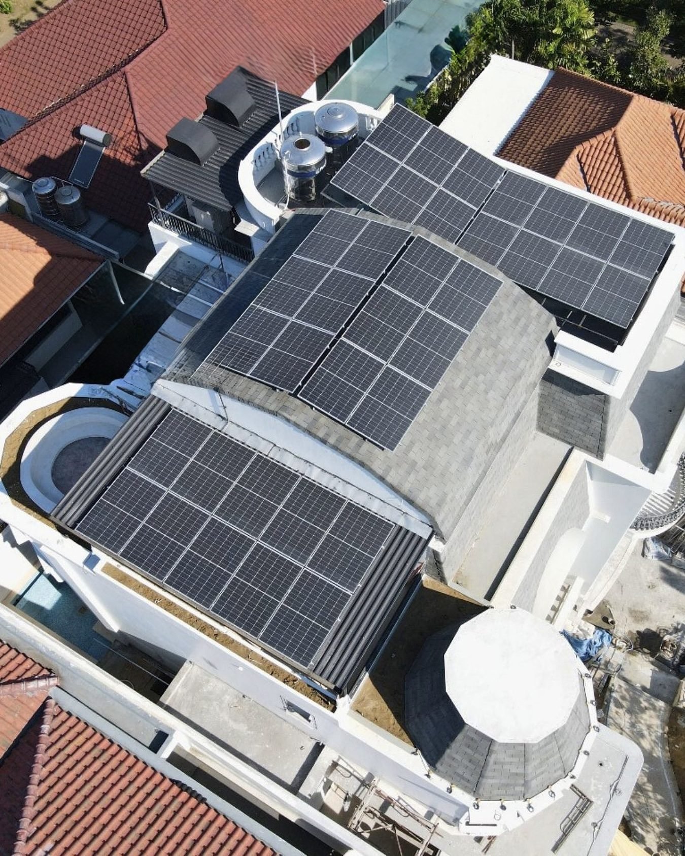 Aerial view of solar panels installed across multiple rooftop sections of a residential property.