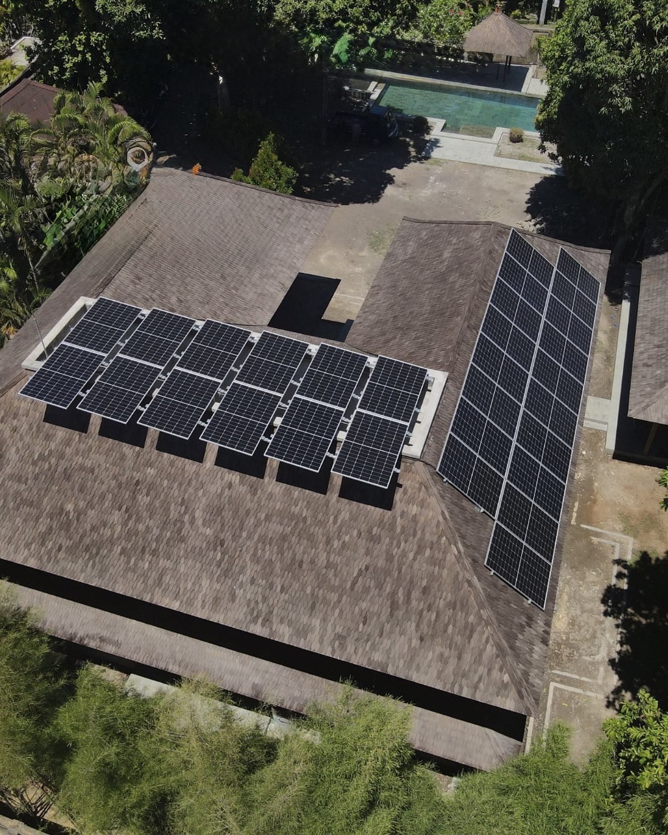 Aerial view of solar panels installed on the rooftop of a residential villa.