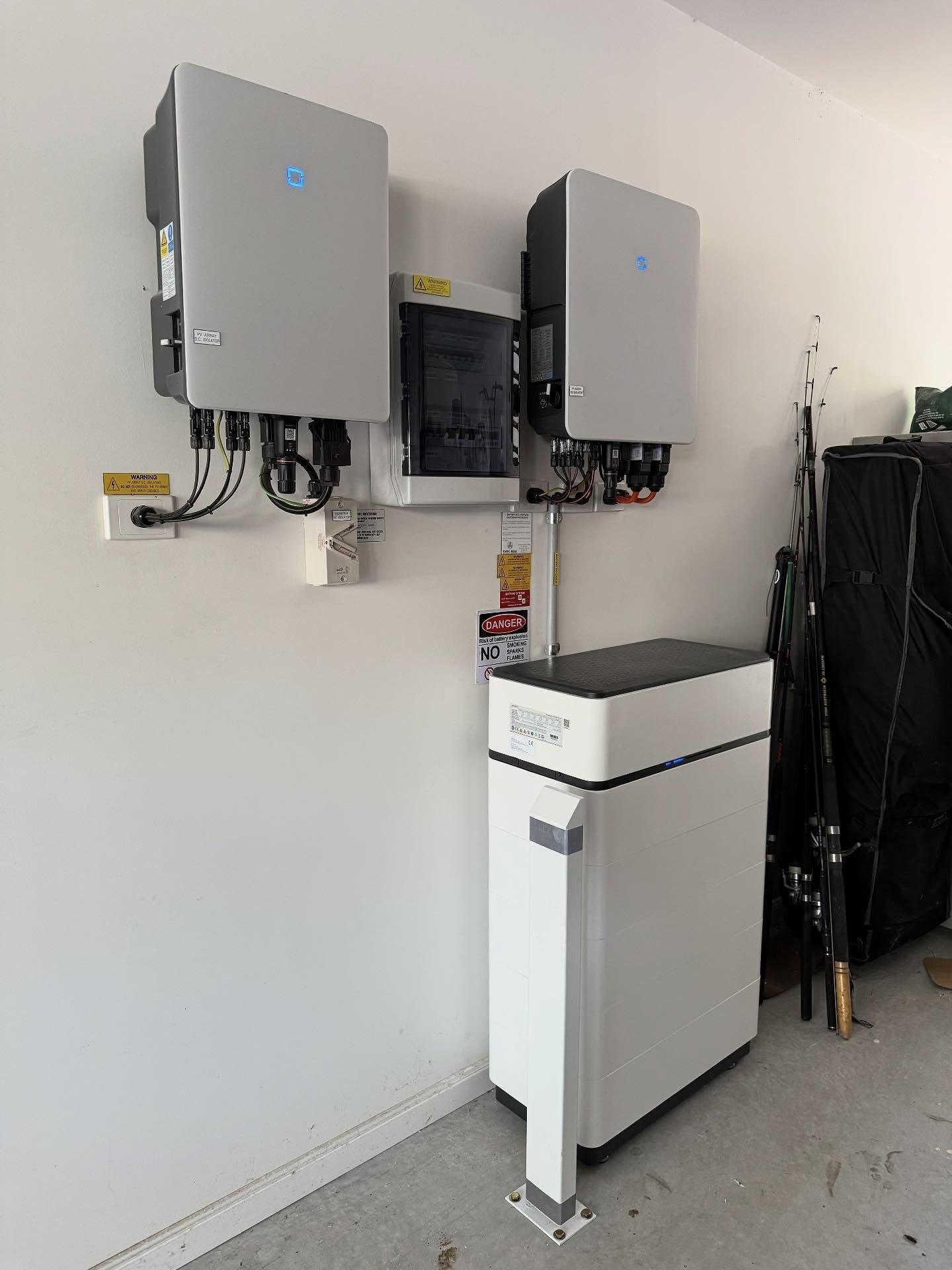 Wall-mounted solar inverter with electrical connections and battery storage system for a residential solar installation.