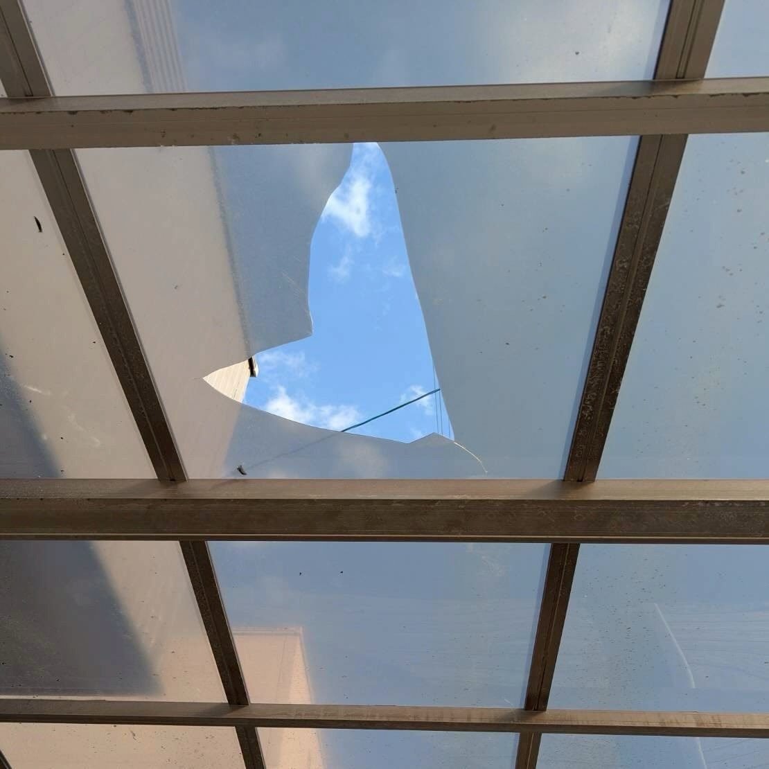 Translucent awning roof panels supported by a metal frame, viewed from underneath